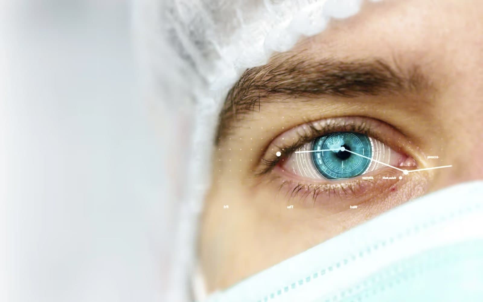 A researcher’s eye in close-up, between a hair net and a face mask, overlaid with lines of data