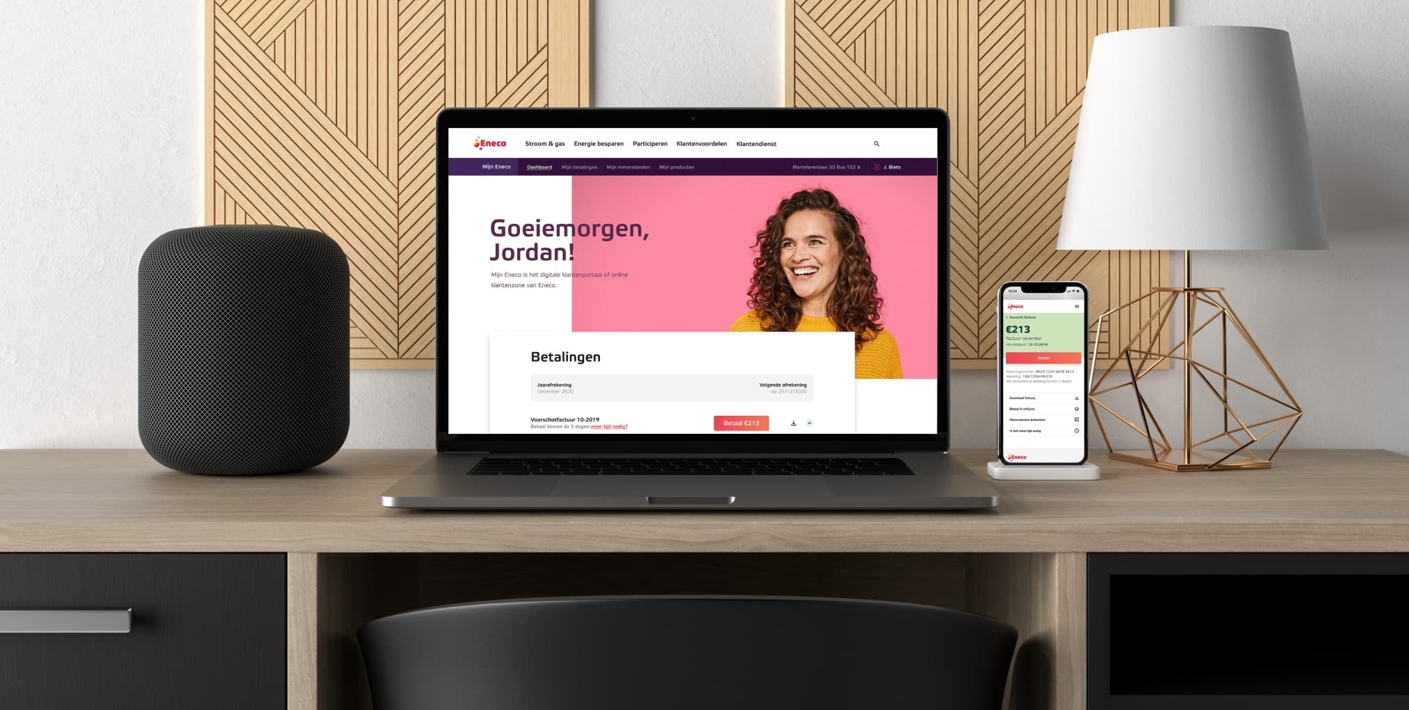 The redesigned Mijn Eneco portal on a laptop and a phone on a desk, greeting the customer by name above their payments