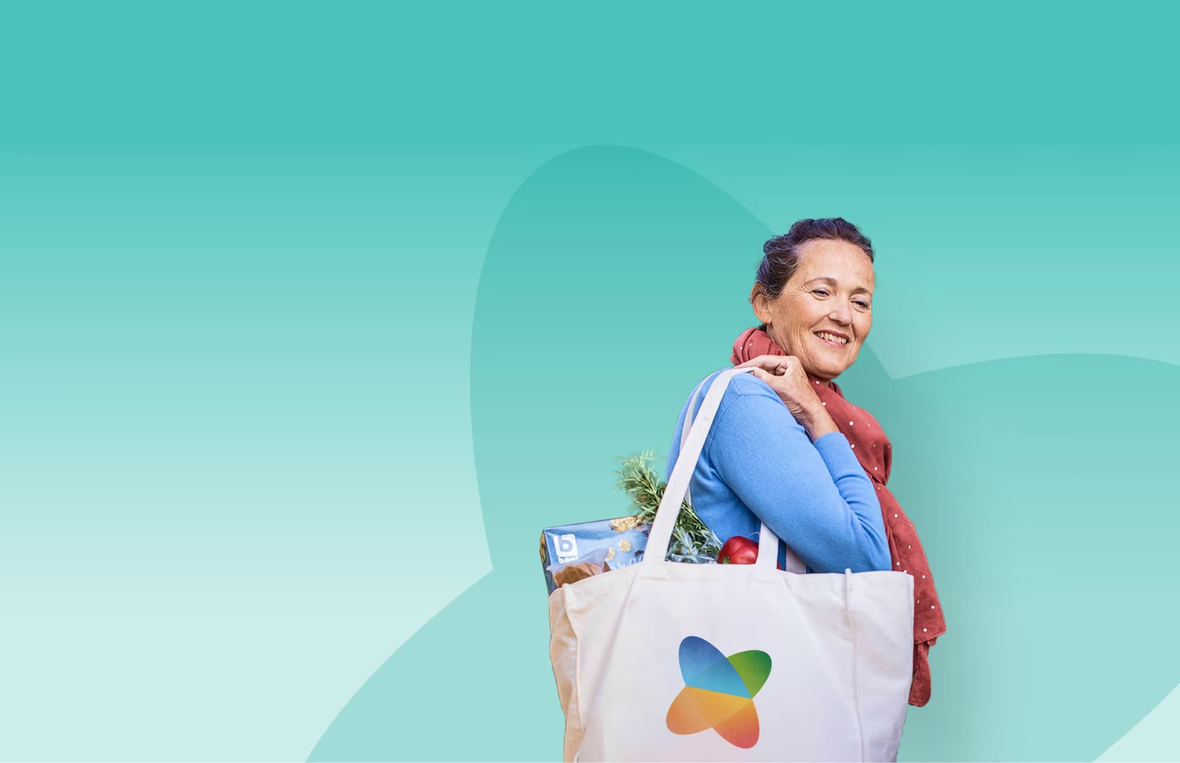 A smiling shopper carrying a tote bag with the Xtra logo, full of groceries